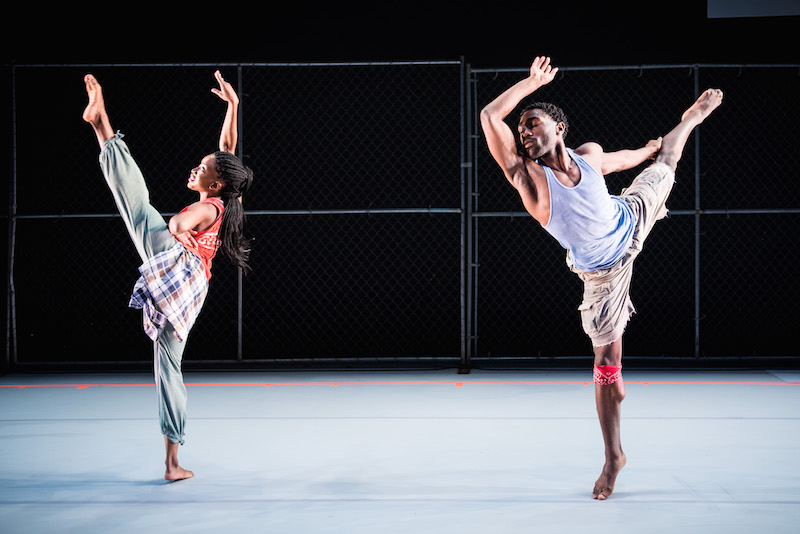 Tamisha Guy extends her leg high into the air while Chalvar Monteiro lifts back leg into a high arabesque